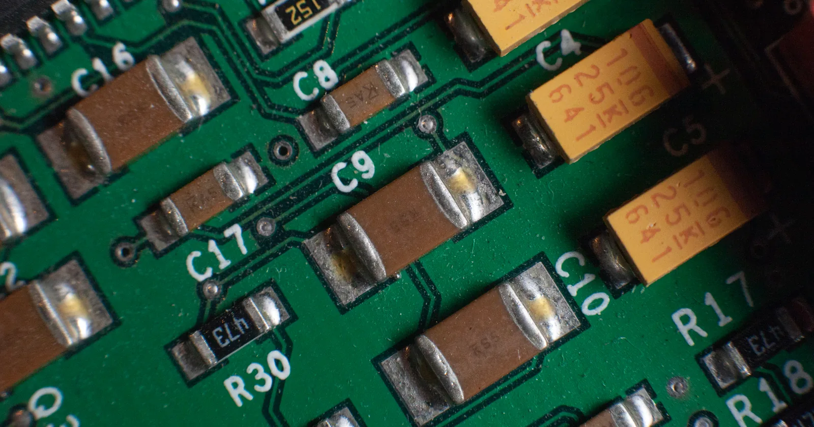 Ceramic and electrolytic capacitors on a green circuit board